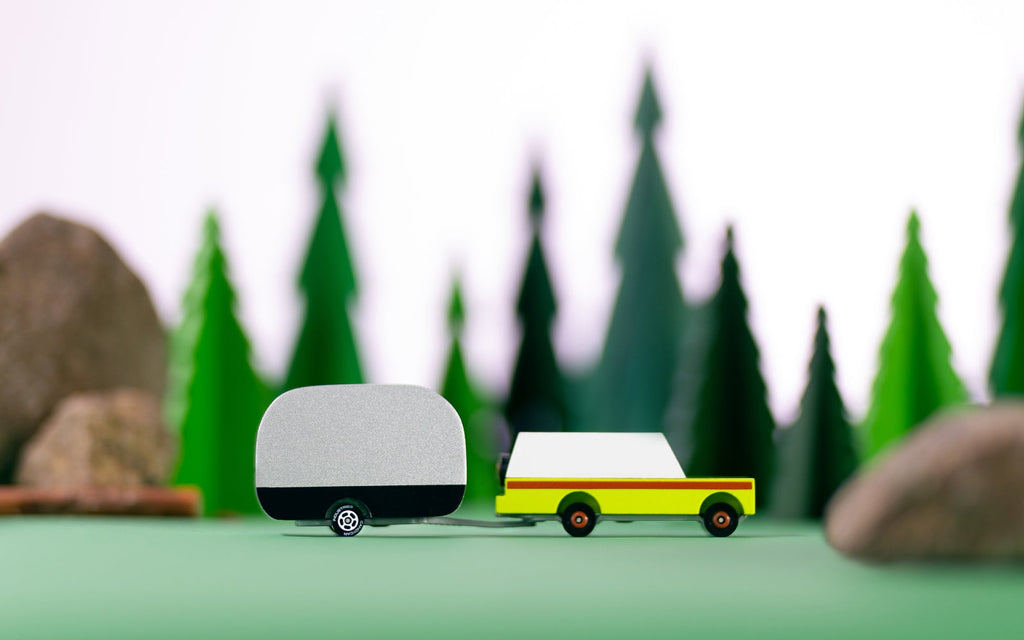 Model of a van with a trailer in front of a forest background