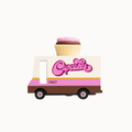 A small toy food truck with a cupcake on top, featuring pink, cream, and brown colors with the word 'Cupcakes' on the side, shown on a plain light background.