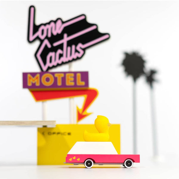 Neon sign for 'Lone Cactus Motel' with a yellow truck graphic on a white background.