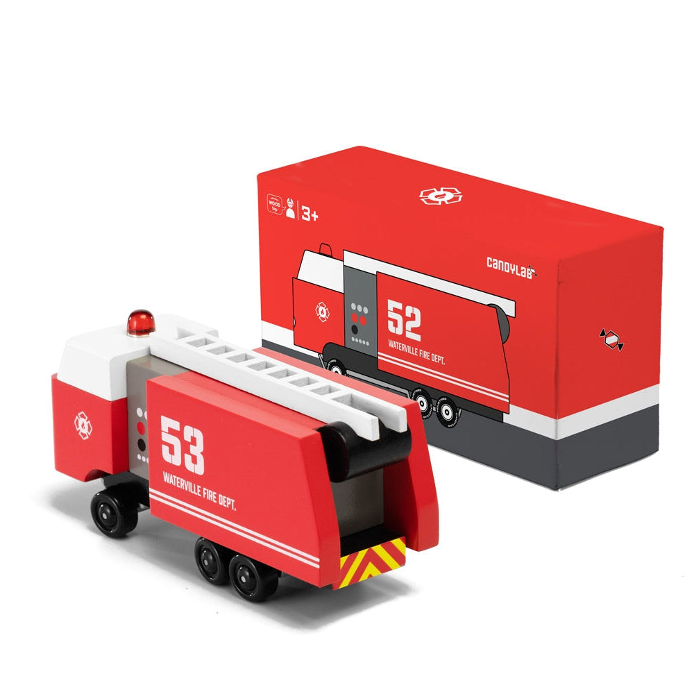 Red toy fire truck with white and gray accents next to its packaging on a white background