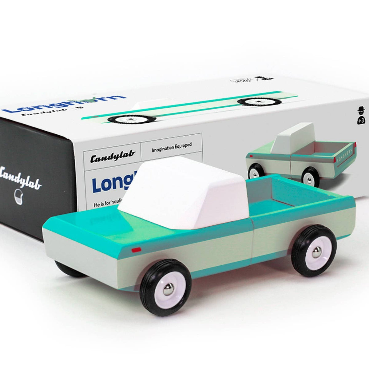 Wooden toy truck with teal roof and gray body in front of a Longtail box.