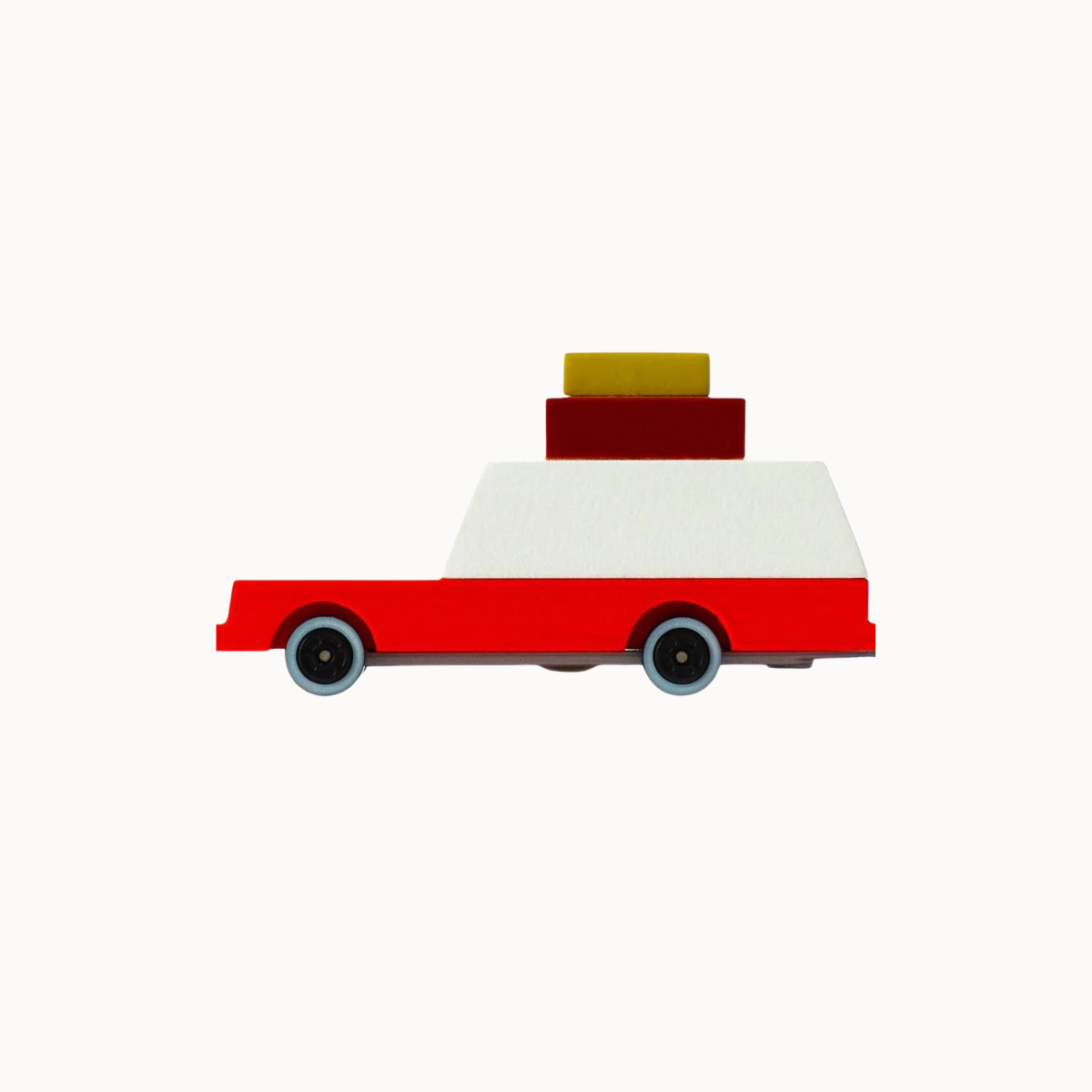 A minimalist wooden toy truck with a red body, a white cargo bed, and stacked yellow and dark red boxes on top, shown in profile against a solid off-white background.