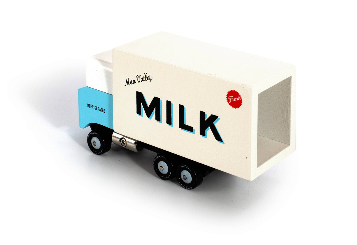 A retro-style toy milk delivery truck with a light blue cab and a cream-colored milk container body, featuring 'MILK' and 'Moo Veezy' printed on the side, set against a plain white background.