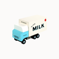 A retro-style toy milk delivery truck with a light blue cab and a cream-colored milk container body, featuring 'MILK' and 'Moo Veezy' printed on the side, set against a plain white background.