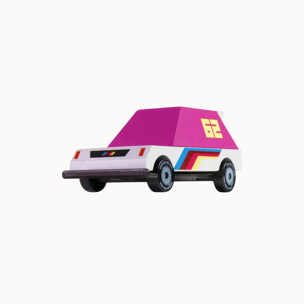 A retro-style toy car with a white body, a bright pink roof, and colorful side stripes in blue, yellow, and red. The number 62 is printed in yellow on the roof.