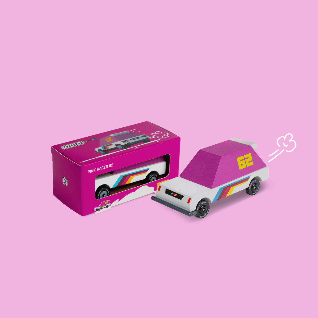 Toy car with pink roof and rainbow stripes next to its packaging on a pink background