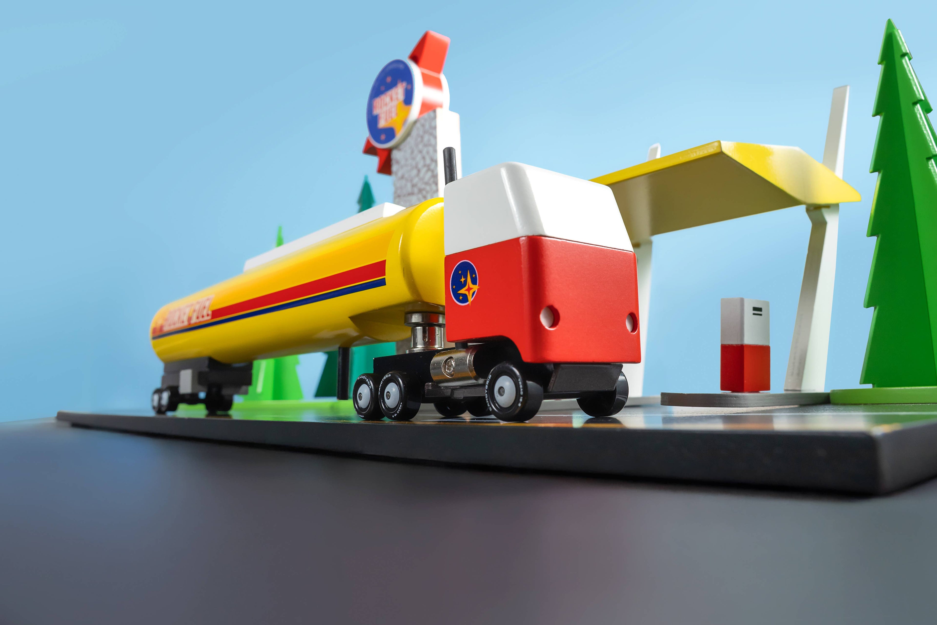Toy gas station with a fuel truck on a blue background