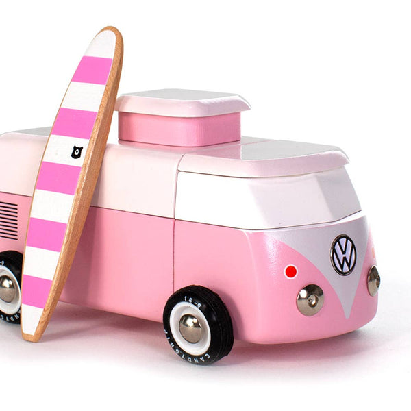 Pink and white Volkswagen camper toy with a striped surfboard on a white background