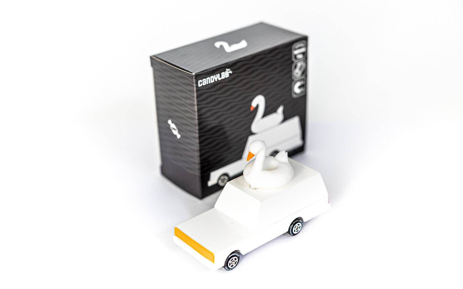White swan-shaped object with packaging on a white background
