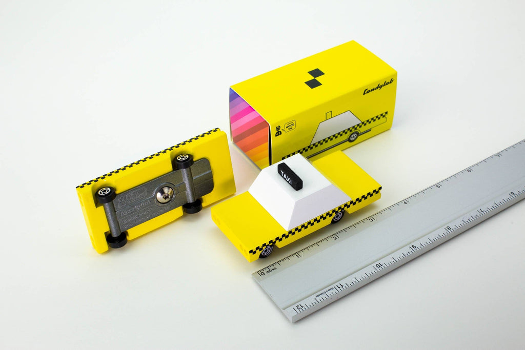 Yellow toy car with a sharpener and packaging on a white background