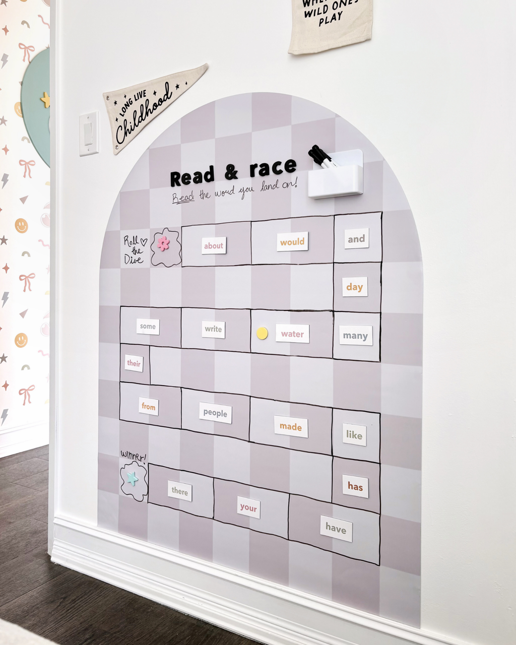 Educational wall chart with magnetic letters on a white wall