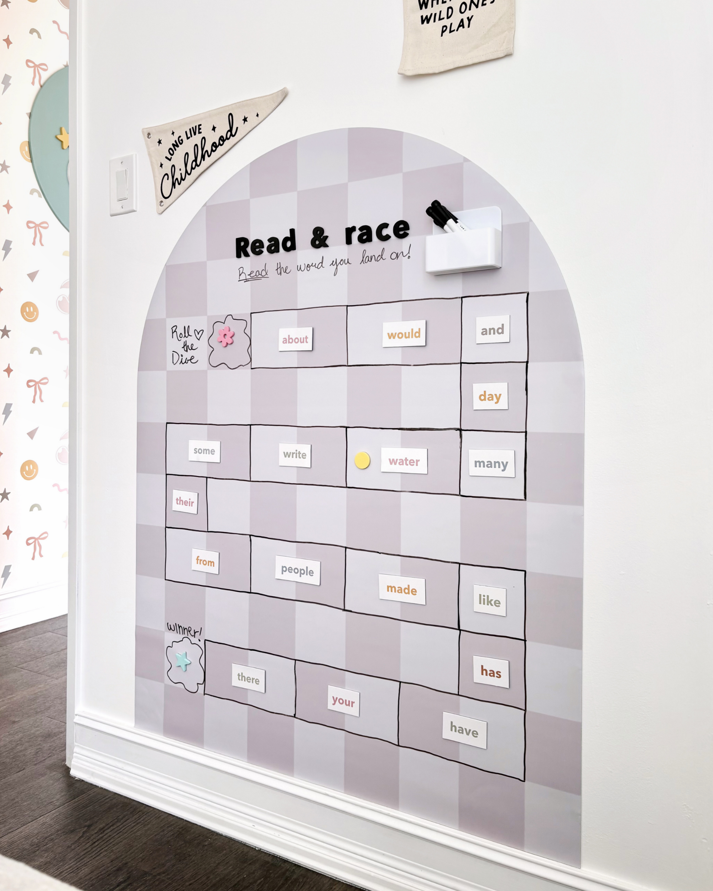 Educational wall chart with magnetic letters on a white wall