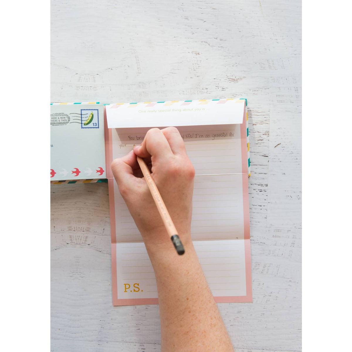 Hand writing on a letter with a pen on a white surface