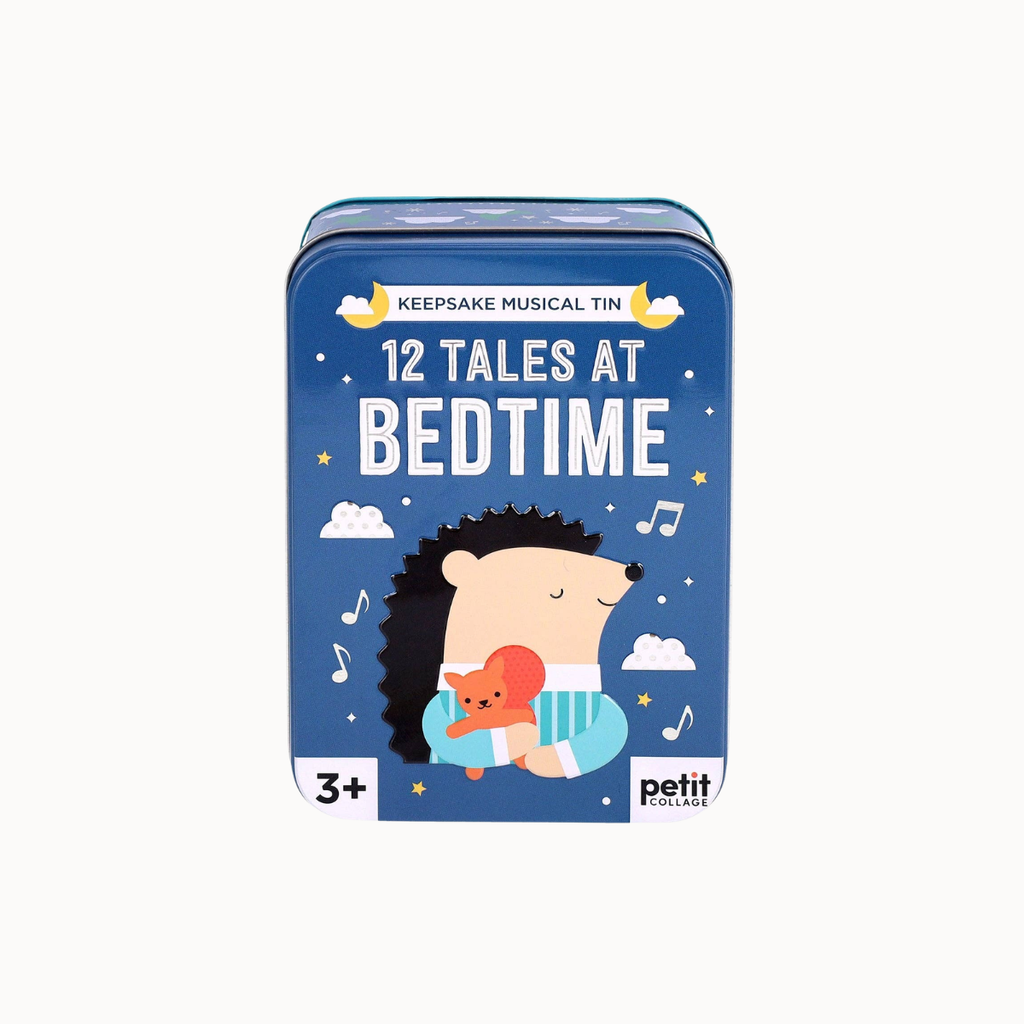 A blue metal tin for keepsake musical toys with the title '12 TALES AT BEDTIME' and a cartoon hedgehog holding a red teddy bear on the front. The brand 'petit english' is visible in the bottom right corner.