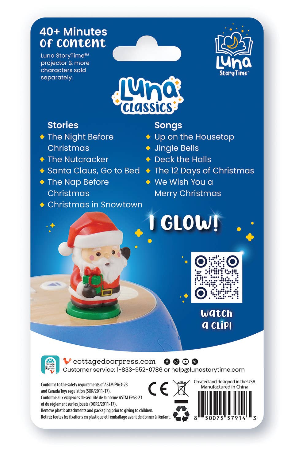 Back of a Luna Classics 'I Glow!' Santa Claus projector card packaging, showing product details, included stories and songs, a QR code, and a small photo of the glowing Santa projector on a tabletop.