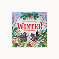 A square children's board book or toy book cover titled 'Winter in the Forest' with 'Lift-a-Flap Surprise' at the top. The cover features a winter forest illustration with holly, red berries, snow, bare tree branches, and two raccoons.