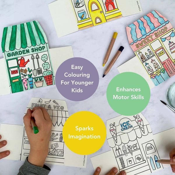 Coloring books with illustrations of shops and a child coloring, on a white surface.