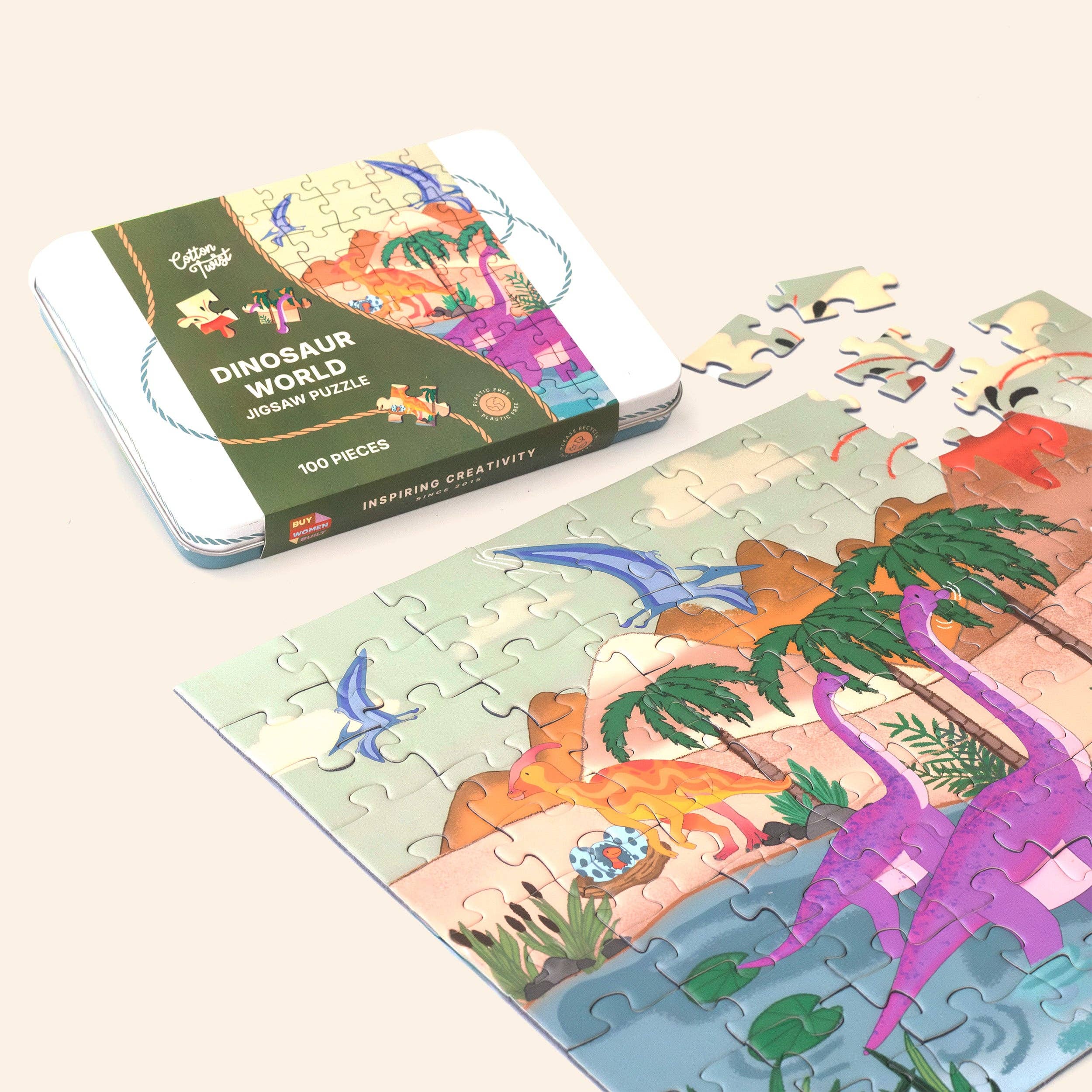 Dinosaur-themed jigsaw puzzle with completed pieces and packaging on a light background