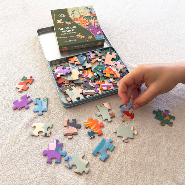 Child playing with dinosaur-themed puzzle pieces on a light surface