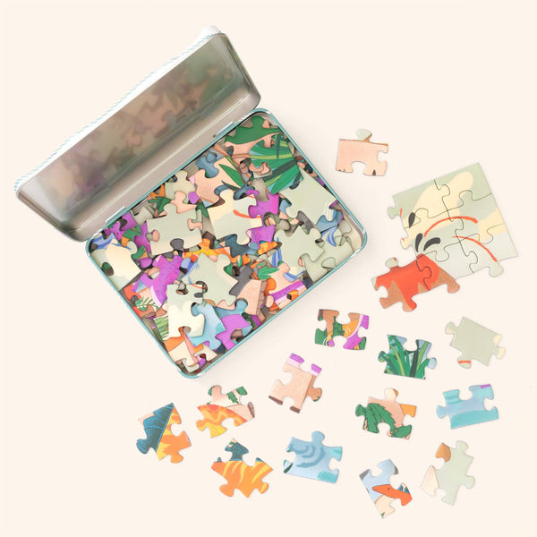 Colorful puzzle pieces in a tin box on a white background