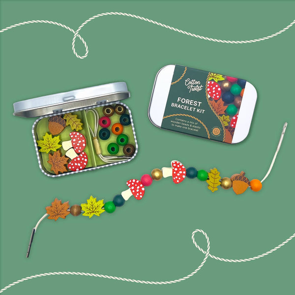 Forest-themed bracelet kit with colorful beads and a tin on a green background