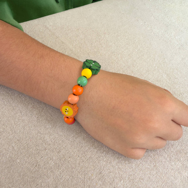 Child's wrist wearing a colorful beaded bracelet on a neutral background