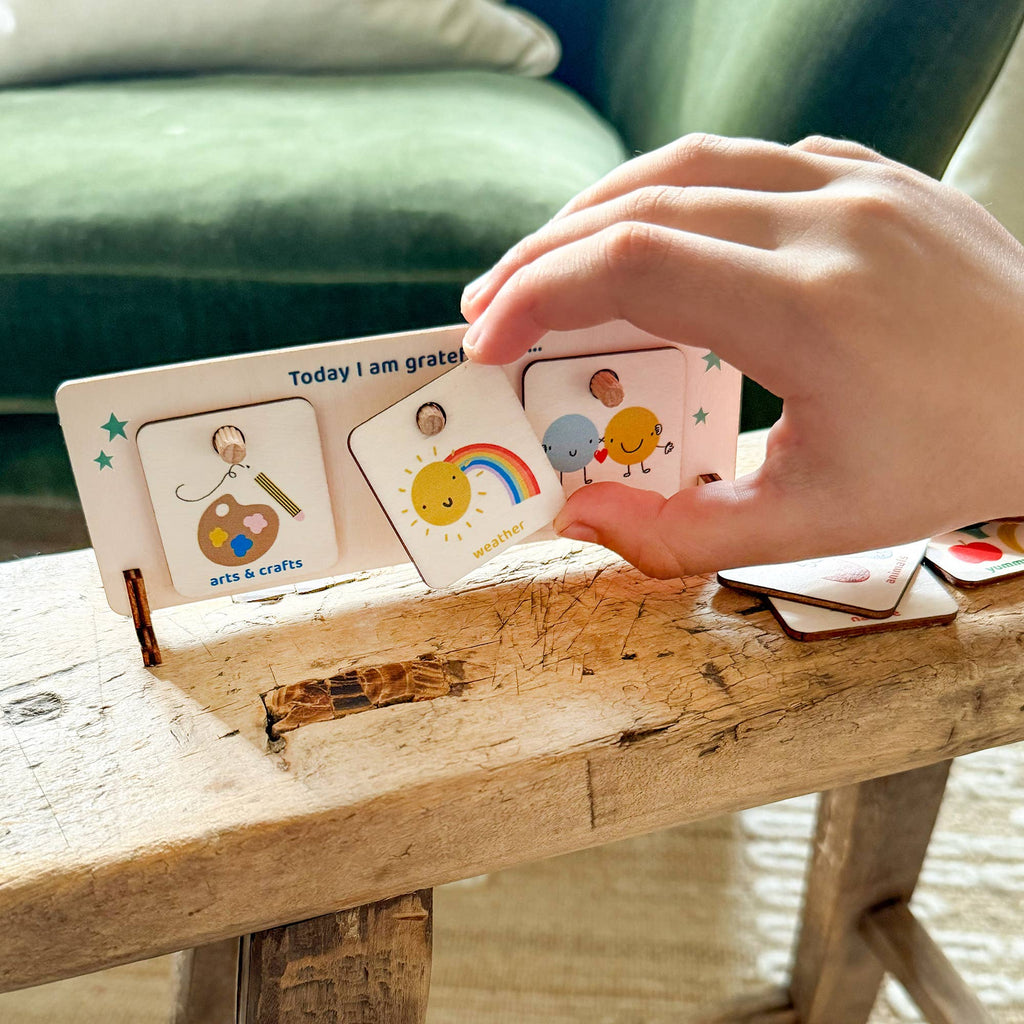 Hand interacting with a set of educational cards on a wooden surface