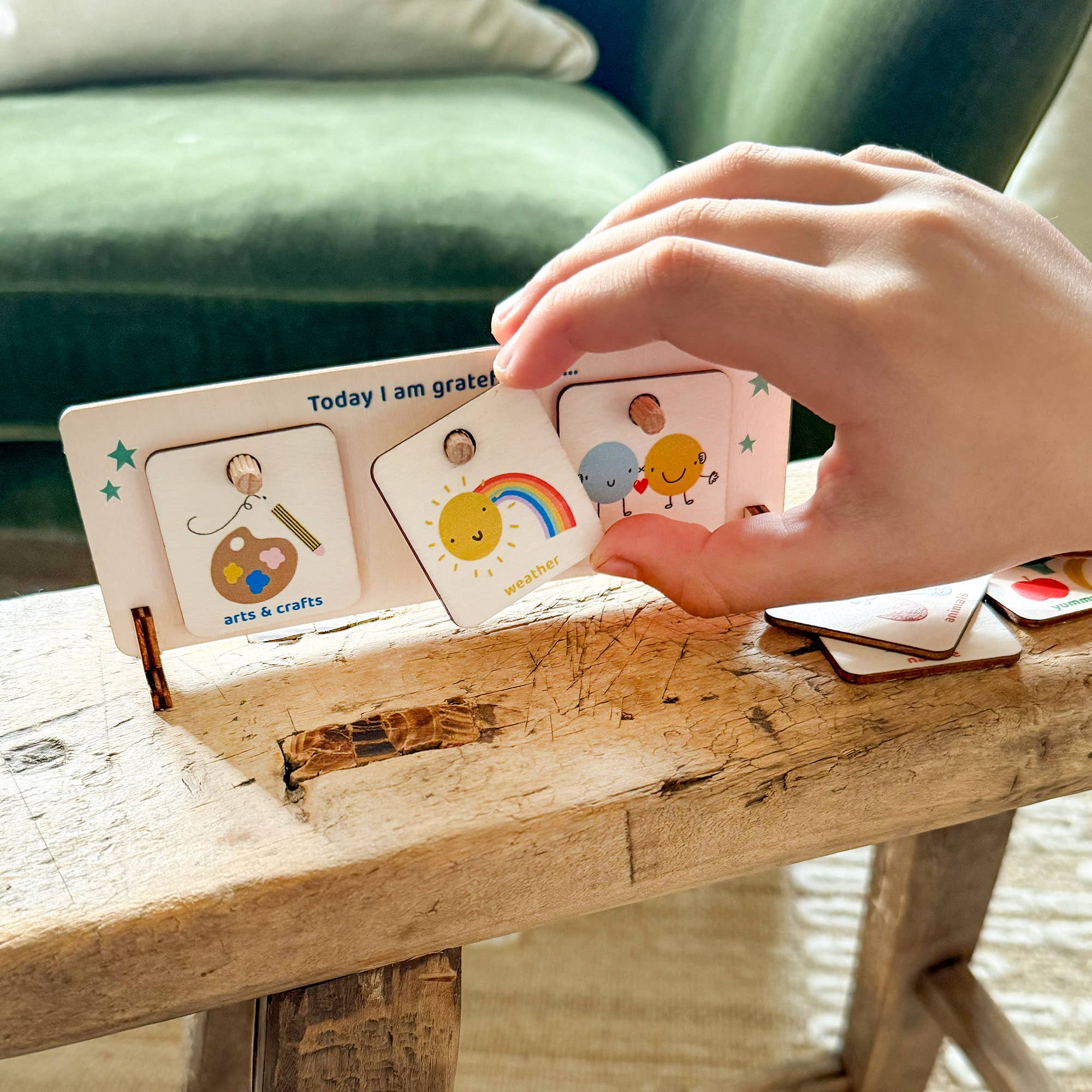 Hand interacting with a set of educational cards on a wooden surface