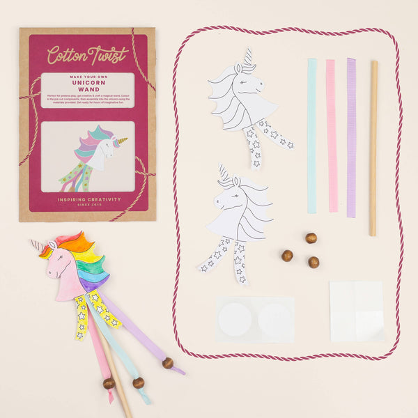 Unicorn-themed craft kit with materials and instructions on a light pink background