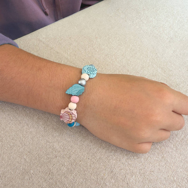 Bracelet with colorful beads on a wrist against a neutral background