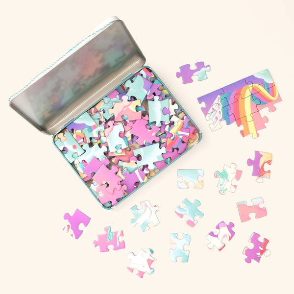 Colorful puzzle pieces in a tin with a few pieces on a white background