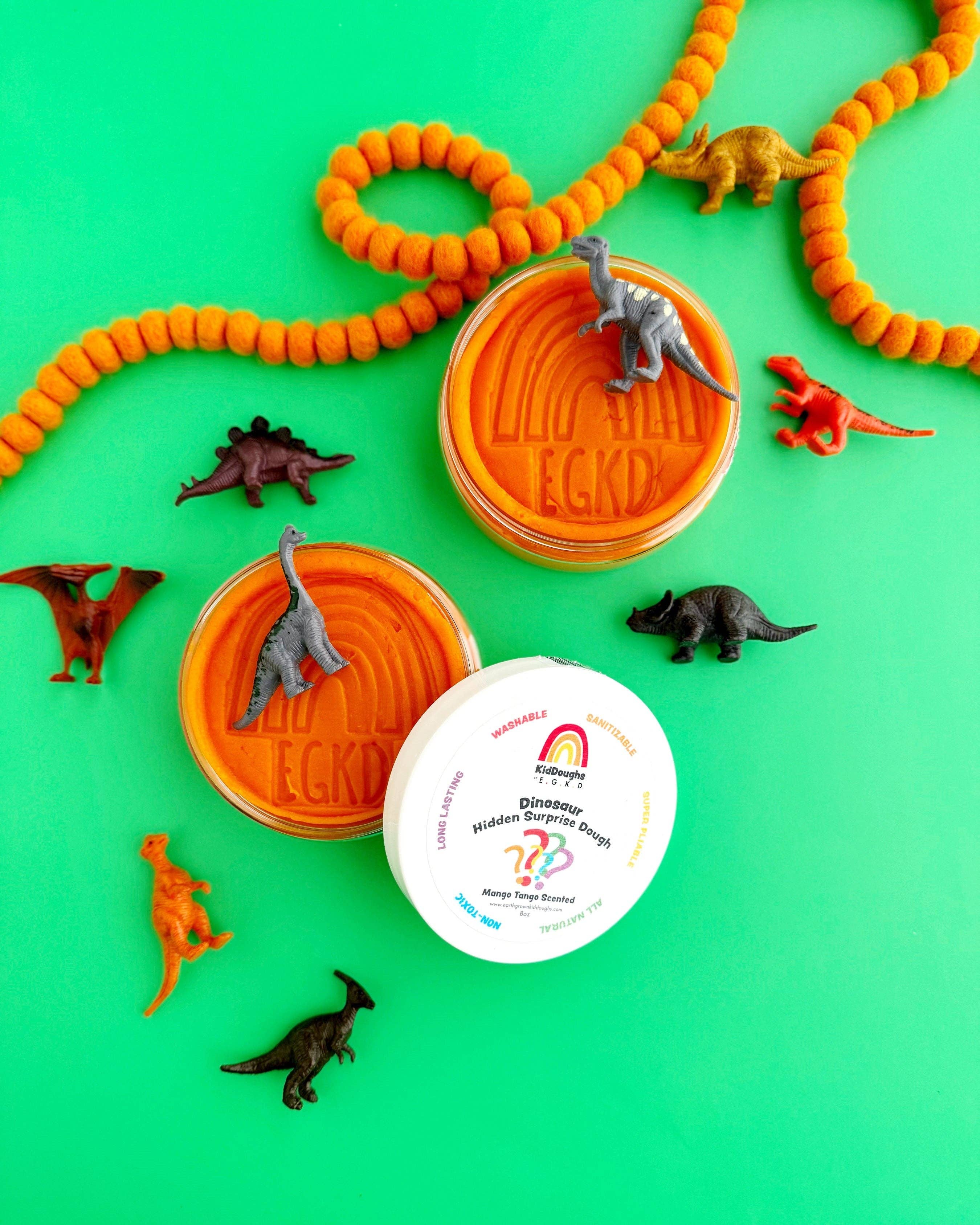 Dinosaur-themed playset with orange molds, toy dinosaurs, and a container on a green background.