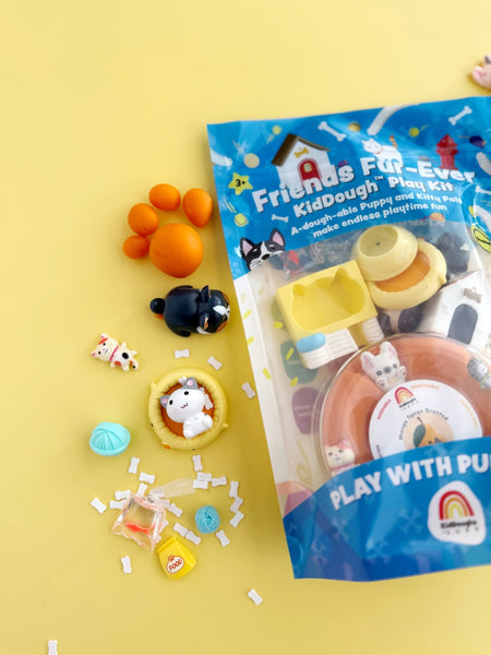 Packaged toy set with colorful dough balls and animals on a yellow background