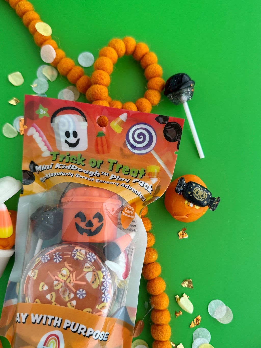 Halloween-themed product with candy on a green background