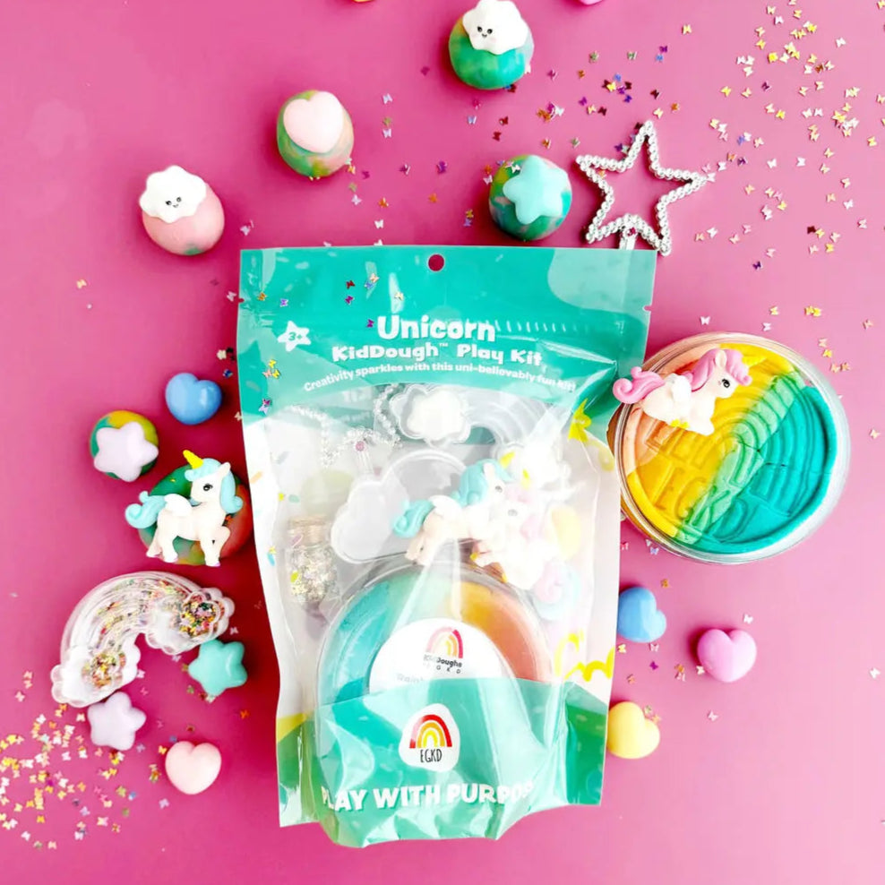 Unicorn-themed kid dough play kit with colorful dough balls on a pink background