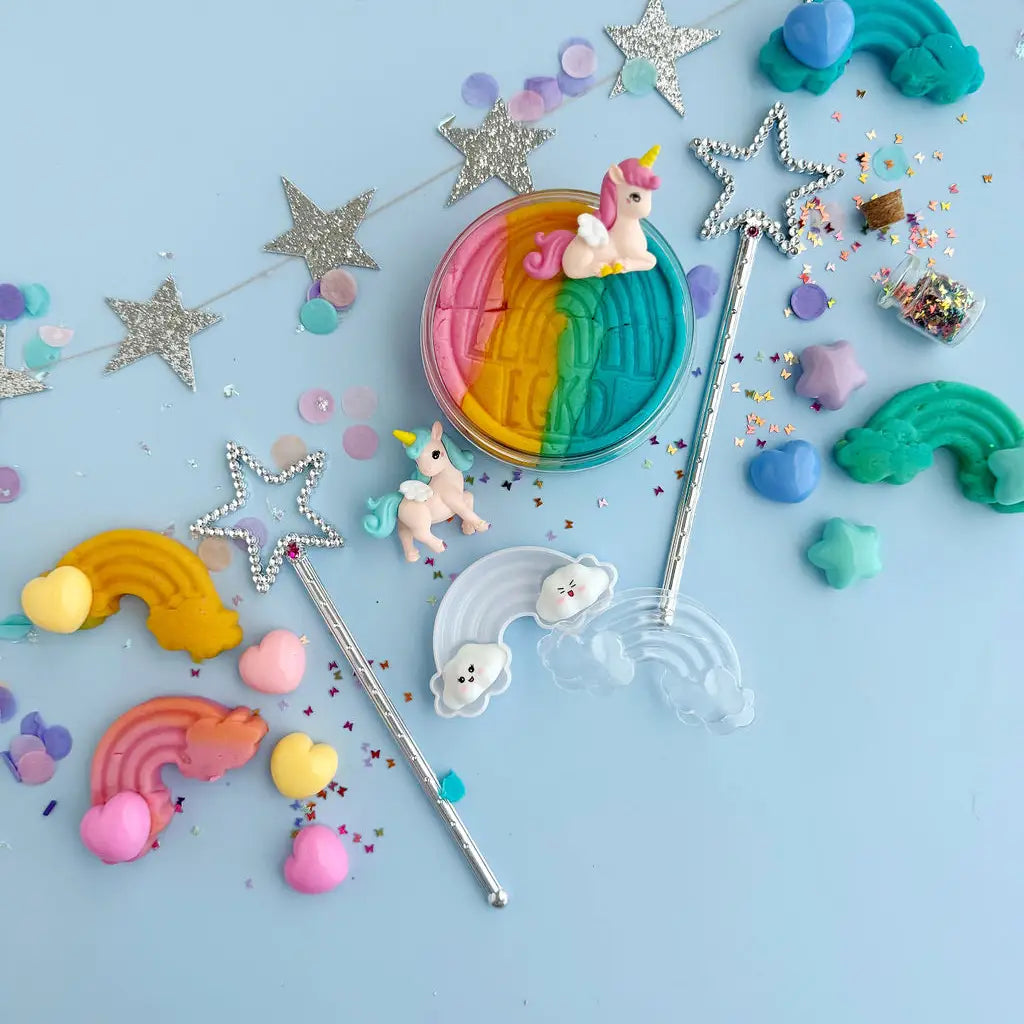 Colorful unicorn-themed items including waffles, stars, and rainbow-shaped objects on a light blue background.