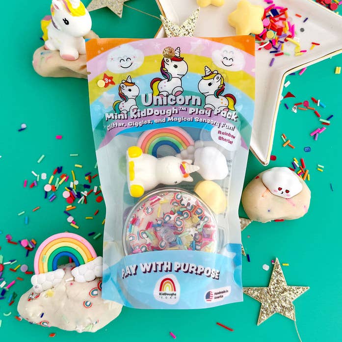 Unicorn-themed play dough set with packaging on a colorful background