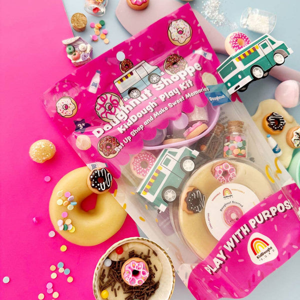 Colorful donut-themed play set with packaging on a pink and blue background