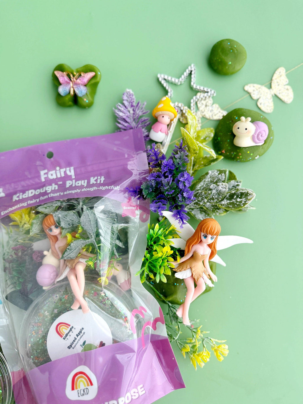 Fairy-themed play kit with figurines and accessories on a green background