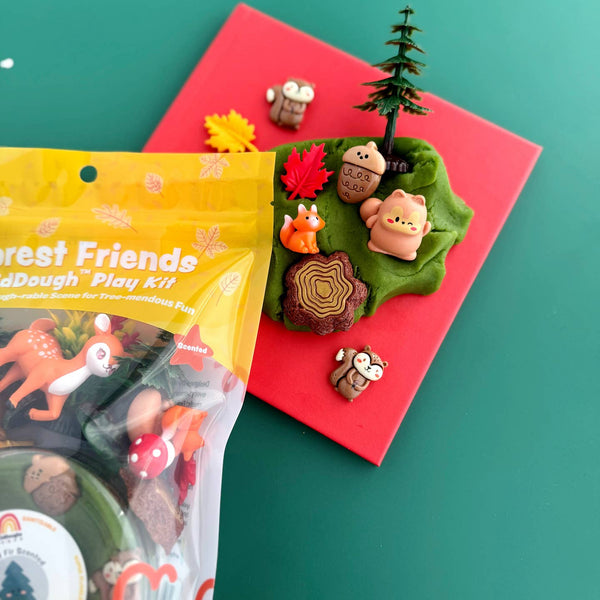 Play dough set with forest-themed figures and packaging on a green background