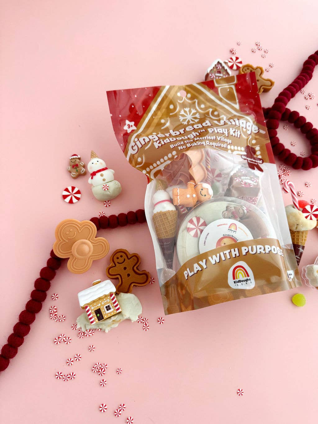 Gingerbread-themed play dough kit with packaging on a pink background