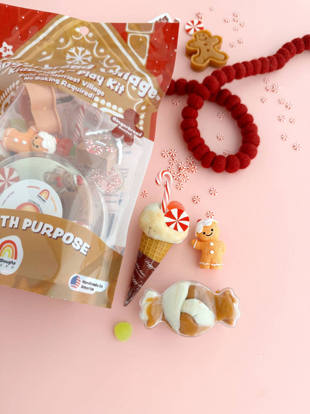 Decorative items including a gingerbread man hair tie, candy-themed earrings, and a craft kit on a pink background.