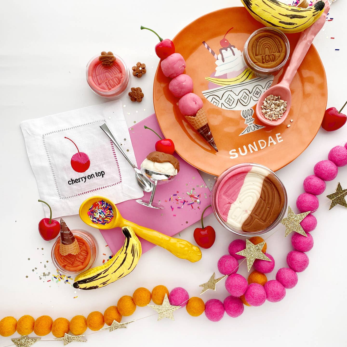 Colorful ice cream-themed table setting with a plate, spoons, and decorative items on a white background.