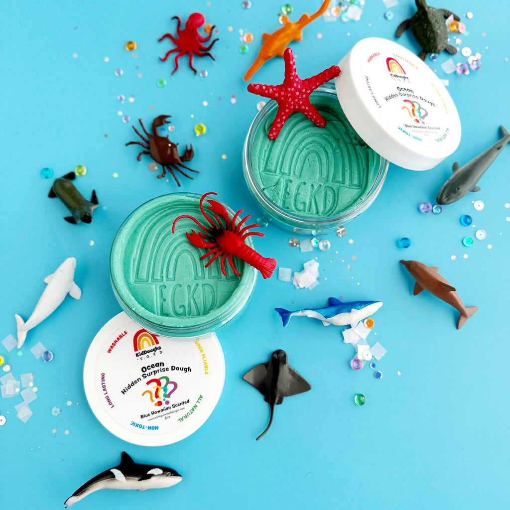 Colorful toy sea creatures with two green containers on a blue background
