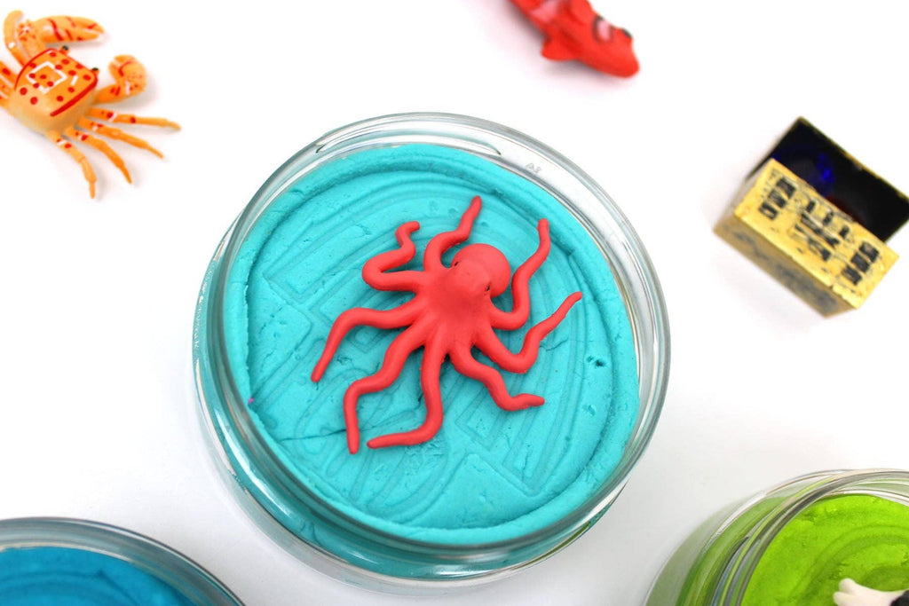 Toy octopus in a blue container with colorful toys around on a white background
