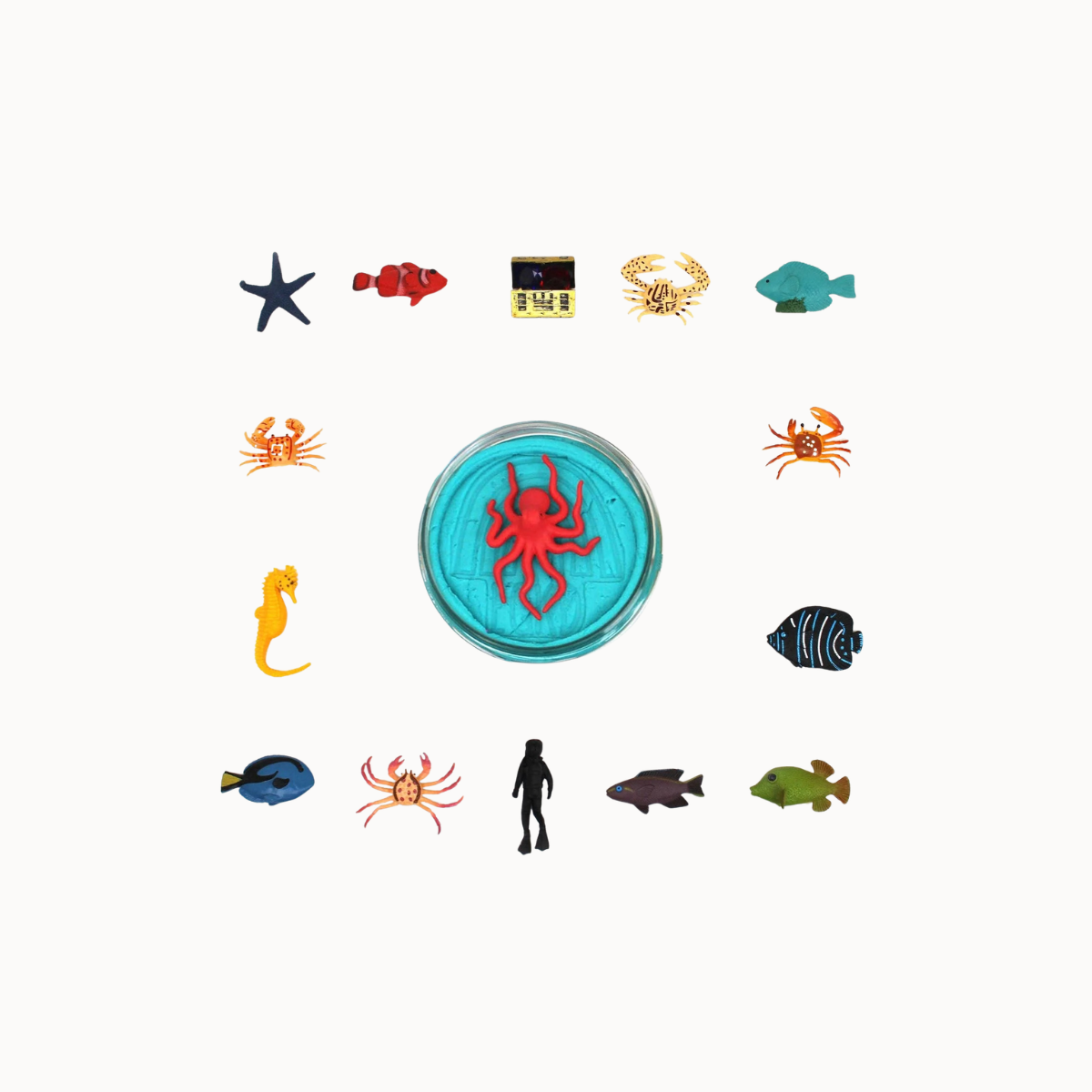 A circular turquoise blue plaque or medallion in the center with a raised red octopus design, surrounded by small colorful sea-themed icons including fish, crabs, a starfish, a seahorse, and a human silhouette on a plain white background.