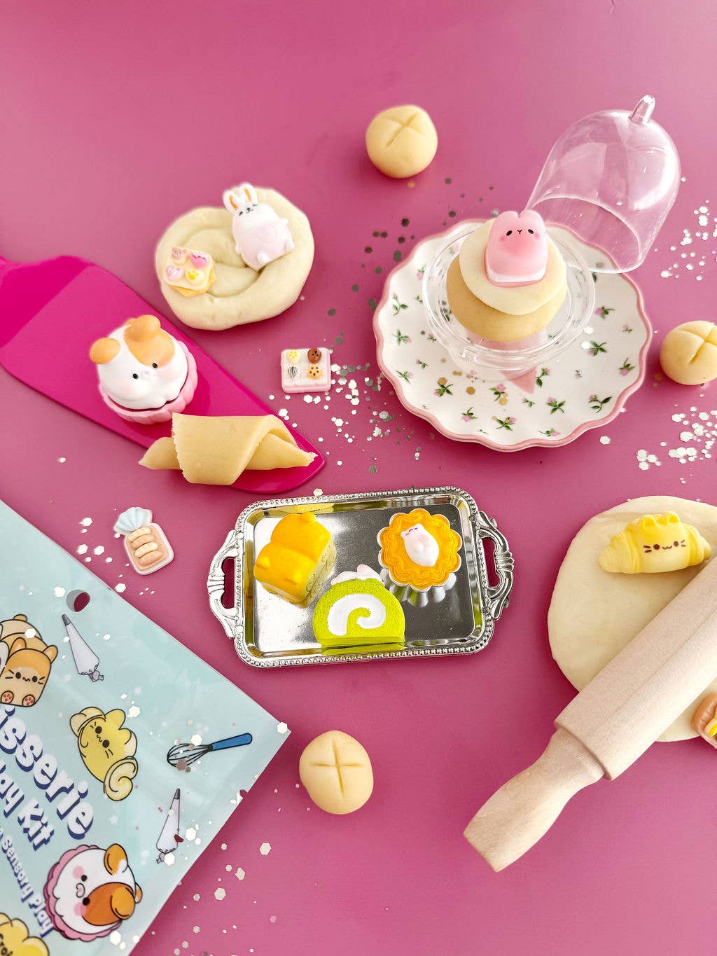 Baking-themed set with cartoon character cookies, rolling pin, and baking tools on a pink background