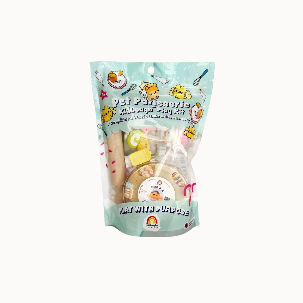 A packaged pet craft kit in a clear stand-up pouch with a light aqua background and cartoon graphics. The pouch shows the text 'Pet Parfume Kidnought Plug Kit' and 'Play With Purpose' near the bottom, with visible craft materials inside through the transparent front.