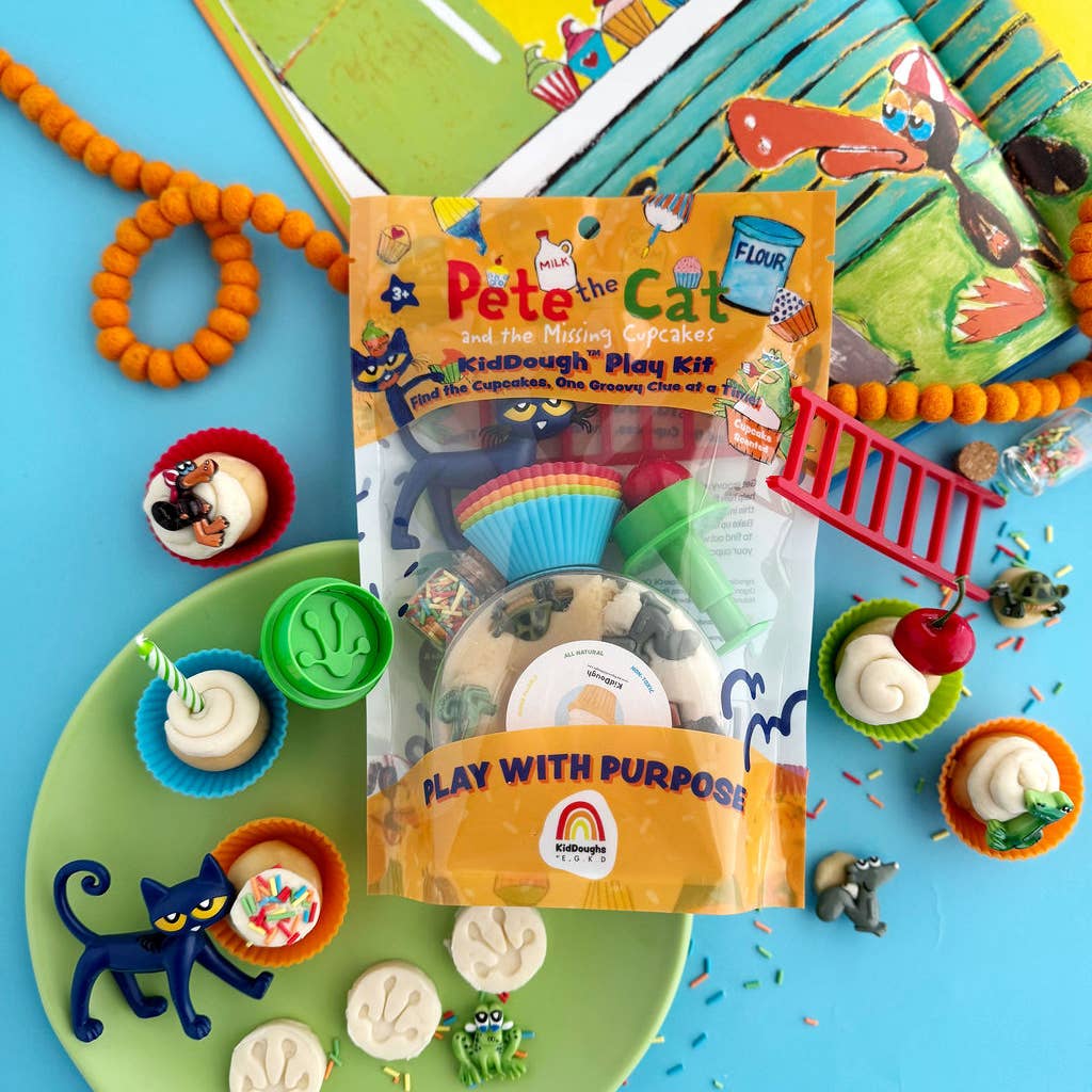 A flat-lay of the Flair Kids 'Pete the Cat Kid Dough Play Kit' in its packaging, surrounded by themed play dough creations on a bright blue background.
