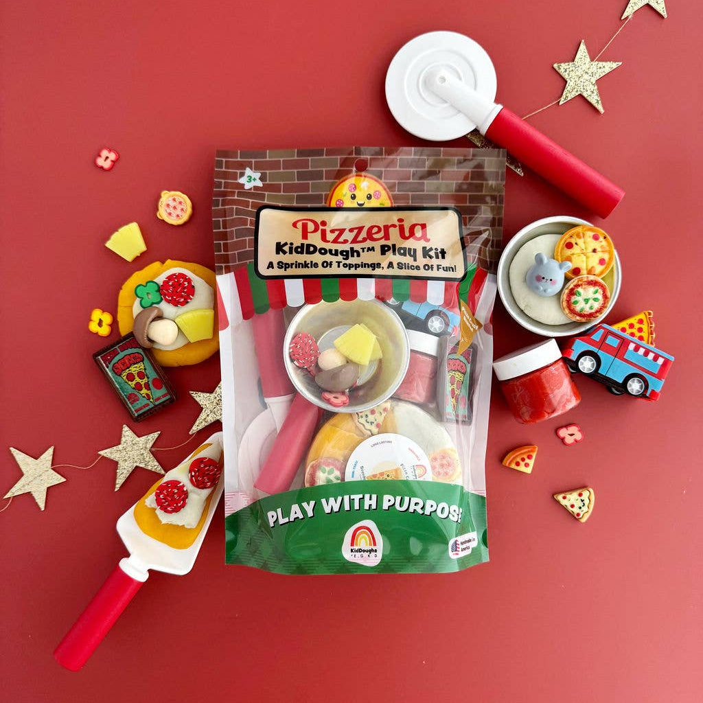 Pizzeria KidDough play kit with toy pizza cutter, rolling pin, and play dough on a red background.